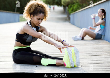 Sportliche Frau zu tun stretching Übung auf einer Brücke Stockfoto