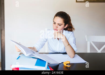 Fokussierte weiblichen Kursteilnehmer lernen am Schreibtisch zu Hause Stockfoto