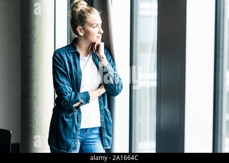 Geschäftsfrau stehen am Fenster im Büro auf der Suche Stockfoto