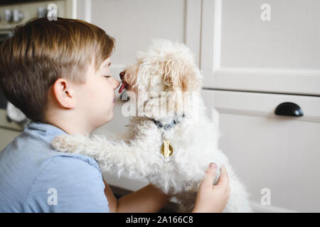 Junge spielt mit seinem Hund zu Hause Stockfoto