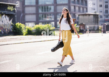 Junge Frau mit Geige Fall gehen auf die Straße Stockfoto