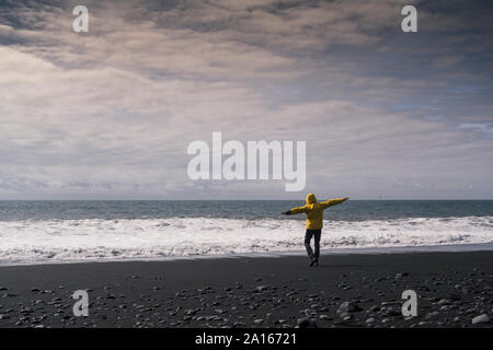 Reifer Mann auf einer Lava Beach in Island, Rückansicht Stockfoto