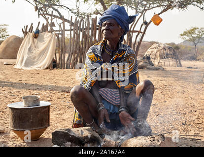 Alte Mucubal Frau kochen in der traditionellen Weise, Tchitundo Hulo, Virei, Angola Stockfoto