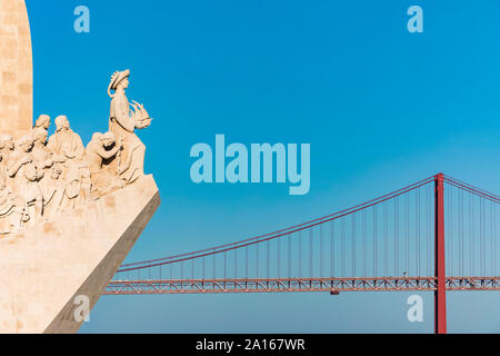 Portugal, Lissabon, Belem, Denkmal der Entdeckungen und 25 de Abril Brücke gegen klaren Himmel Stockfoto