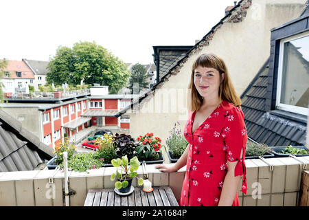 Portrait von lächelnden jungen Frau, die auf dem Balkon Stockfoto