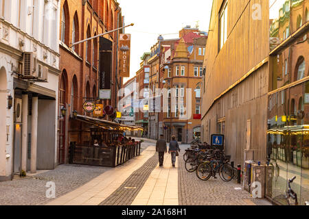 Ansicht der Rückseite des Menschen zu Fuß auf der Straße inmitten von Wohngebäuden in Malmo City Stockfoto