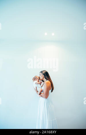 Mutter küssen ihr baby boy im Innenbereich Stockfoto