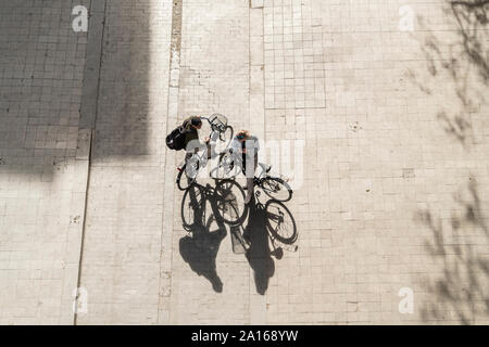 Blick von oben auf die zwei Personen mit Fahrrädern Stockfoto