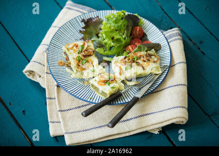 Schwäbische Taschen mit gebratenen Zwiebeln, Käse und Salat Stockfoto