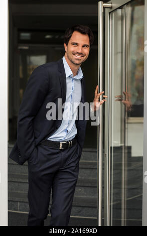 Portrait von lächelnden Geschäftsmann stand an der offenen Tür Stockfoto