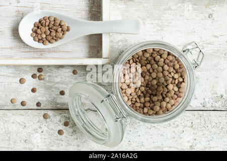 Jar von Linsen auf hölzernen Tisch von oben gesehen Stockfoto