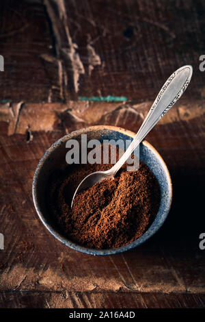 Gemahlener Kaffee im rustikalen Keramik Tasse. Holz- Hintergrund. Noch immer leben Stockfoto