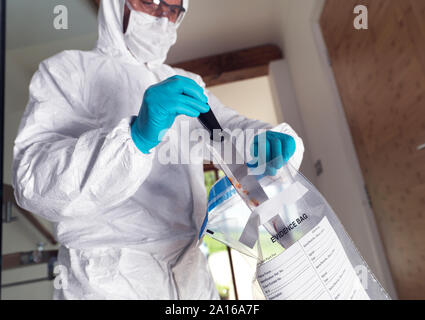 Forensische Wissenschaftler Einsacken ein Messer aus einem Gewaltverbrechen Szene Stockfoto