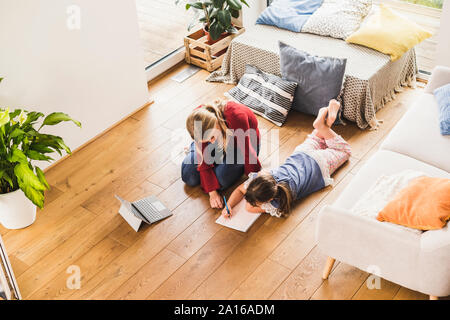 Mutter, Tochter mit den Hausaufgaben zu Hause Stockfoto