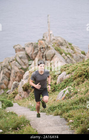 Trail Runner auf Treppen in Küstenlandschaft, Ferrol, Spanien Stockfoto