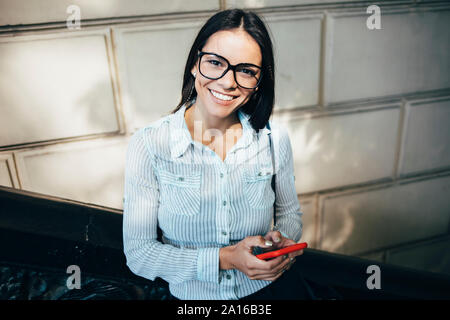 Porträts der glückliche junge geschäftsfrau mit Handy im Freien Stockfoto