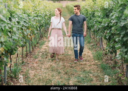 Glückliches junges Paar Hand in Hand in den Weinbergen Stockfoto