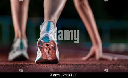 Beine der weiblichen Athleten laufen auf der Tartanbahn Stockfoto