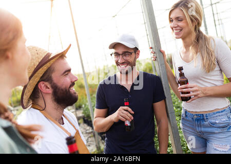 Gruppe von Freunden Bier trinken und genießen die Zeit im Gewächshaus Stockfoto