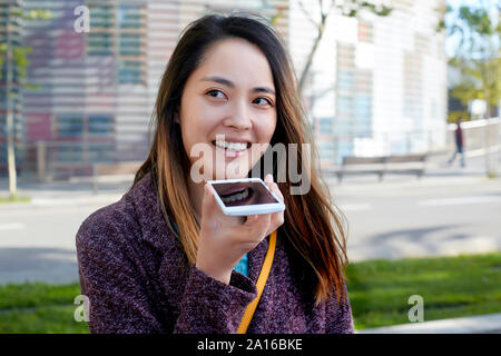 Frau Senden einer Sprachnachricht mit Handy, Barcelona, Spanien Stockfoto