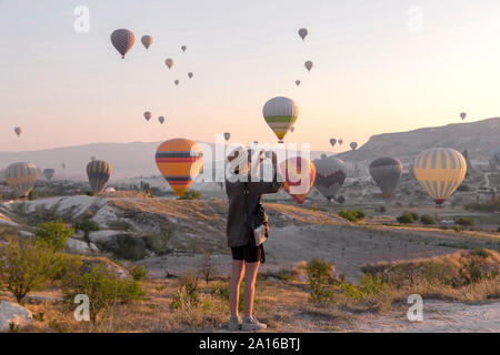 Junge Frau und Heißluft-ballons, Göreme, Kappadokien, Türkei Stockfoto