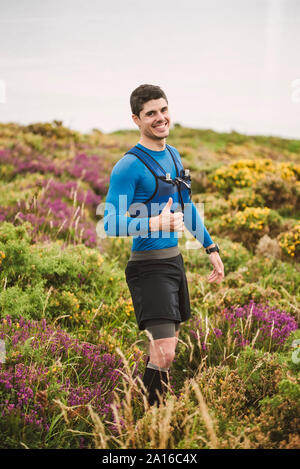 Portrait von lächelnden Trail Runner stehen in der Natur, Ferrol, Spanien Stockfoto