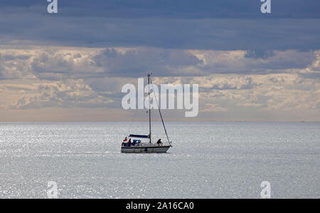 Segelyacht überschrift in West Bay, gesehen vom East Cliff Beach, Bridport, Dorset, England, Großbritannien Stockfoto