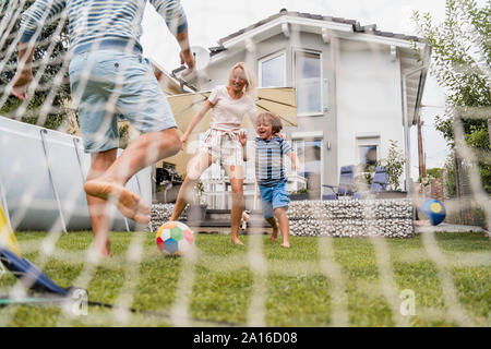 Glückliche Familie Fußball spielen im Garten Stockfoto