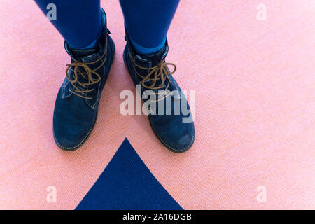 Schnürschuhe Stiefel stehen in der Nähe der passenden blauen Teppich Muster Stockfoto