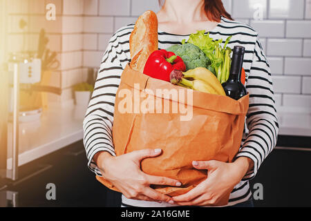 Frau mit einer Papiertüte mit Produkten aus dem Supermarkt oder Farmers Market in Ihrer Küche Stockfoto