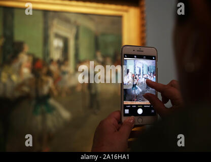 Paris, Sept. 24. 19 Jan, 2020. Ein Besucher nimmt ein Foto von einem Gemälde in der Ausstellung 'Degas an der Oper" am Musée d'Orsay in Paris, Frankreich, Sept. 24, 2019. Die Ausstellung dauert bis 19.01.2020. Credit: Gao Jing/Xinhua/Alamy leben Nachrichten Stockfoto