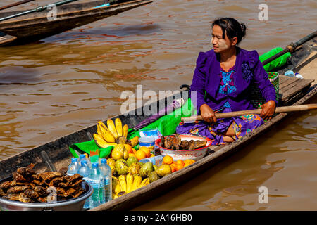 Eine burmesische Frau Verkaufen Frisches Obst und Snacks von einem Boot auf See Inle, Shan Staat, Myanmar Stockfoto