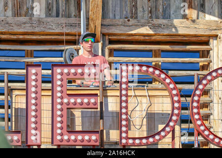 DJ mit Baseballmütze und Sonnenbrille tritt mit seinem Mixer auf einer Holzbühne auf. Vom La Folie Douce Saint Gervais Restaurant Apres Ski Party Chamonix Stockfoto