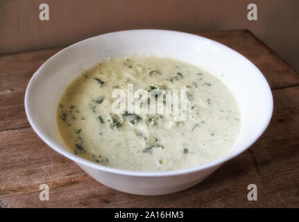 Teig für Gemüse Zucchini Pfannkuchen mit Kräutern, die in weiße Schüssel. Selektive Weichzeichner. Text kopieren. Sommer Herbst Gemüse ernten Konzept Stockfoto