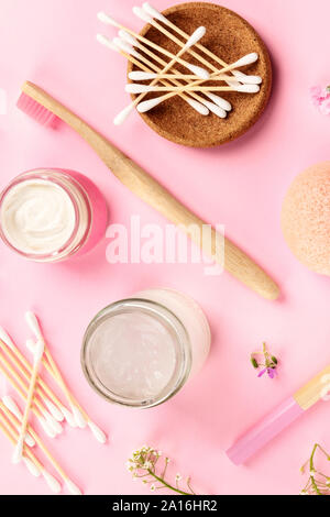 Kunststoff, null Abfall Kosmetik, flach Muster auf einem rosa Hintergrund. Bambus Zahnbürsten und Wattestäbchen, selbstgemachte Cremes etc., geschossen von oben Stockfoto