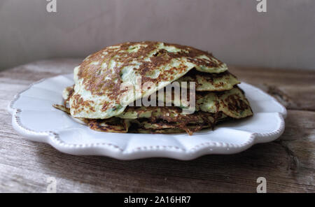 Zucchini Pfannkuchen mit Kräutern auf weißen Teller stapeln. Selektive Weichzeichner. Text kopieren. Sommer Herbst Gemüse ernten Konzept Stockfoto