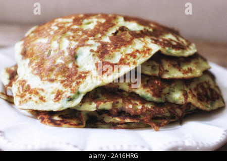 Zucchini Pfannkuchen mit Kräutern auf weißen Teller stapeln. Selektive Weichzeichner. Text kopieren. Sommer Herbst Gemüse ernten Konzept Stockfoto