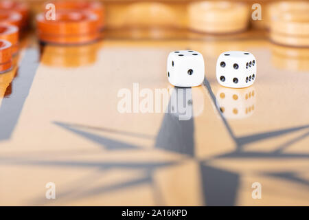Würfel und Spielsteine auf einem hölzernen Spielbrett. Spiel Würfel werden auf der Oberfläche des Backgammon board wider. Close Up. Auf Würfel 4 2 Stockfoto