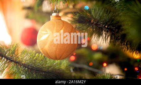 Closeup getönten Foto der Schönen sprakling Chrismtas baum Christbaumkugel hängen auf Zweig gegen Sonnenstrahlen glänzenden durch große Fenster Stockfoto