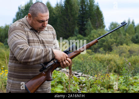 Der Jäger sein Gewehr Vorbereitung für Aufnahmen Stockfoto