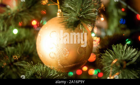 Closeup abstraktes Bild der Goldenen Christbaumkugel mit funkelt am Weihnachtsbaum. Ideal für Winterurlaub und Feiern Stockfoto