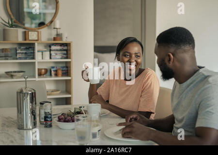 Lachende junge afrikanische amerikanische Paar beim Frühstück zusammen zu Hause Stockfoto