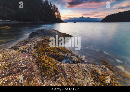 Felsigen Strand Sonnenuntergang entlang des Pacific North West Bowen Island in Howe Sound mit spektakulärem Blick auf den Leuchtturm alle direkt an der Küste von Vancouver BC Stockfoto