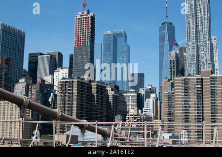 Blick auf die Skyline von Lower Manhattan mit der Stahlkonstruktion der Brooklyn Brücke im Vordergrund. Das One World Trade Center und Gehry Berndorf sieht Stockfoto