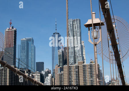 Blick auf die Skyline von Lower Manhattan mit der Stahlkonstruktion der Brooklyn Brücke im Vordergrund. Das One World Trade Center und Gehry Berndorf sieht Stockfoto