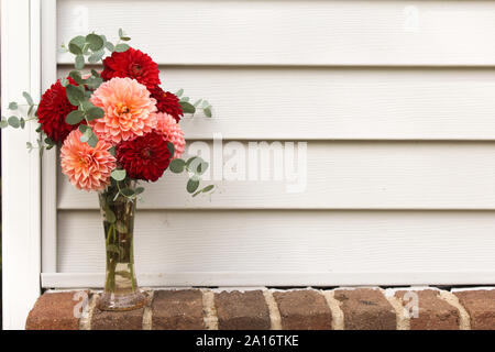 Vase voller Dahlia Blumen und Eukalyptus Grüns Vor der Weißen Abstellgleis Hintergrund Stockfoto