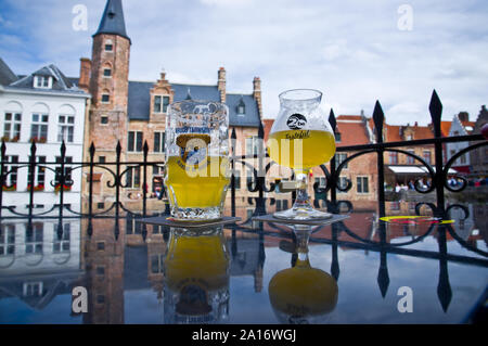 Zwei belgische Biere in Gläsern durch die glänzende Oberfläche reflektiert. Brügge, Belgien. Stockfoto