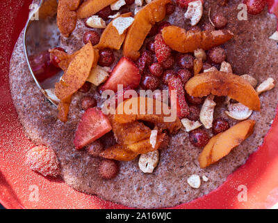 Ansicht von oben in der Nähe eines Hause paleo Porridge aus Voll fett Kokosmilch und Samen mit organischen Früchten und Nüssen und ohne Zusatz von Zucker Stockfoto