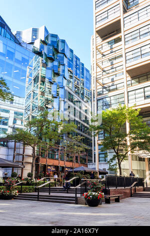 Bäume spiegeln sich in den verspiegelten Fenstern von Bürogebäuden und Einzelhandelsgeschäften in der Fußgängerzone des Fleet Place in der City of London, Großbritannien Stockfoto