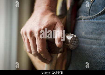 Die Hände eines männlichen Builder ruht auf einem Hammer. Stockfoto